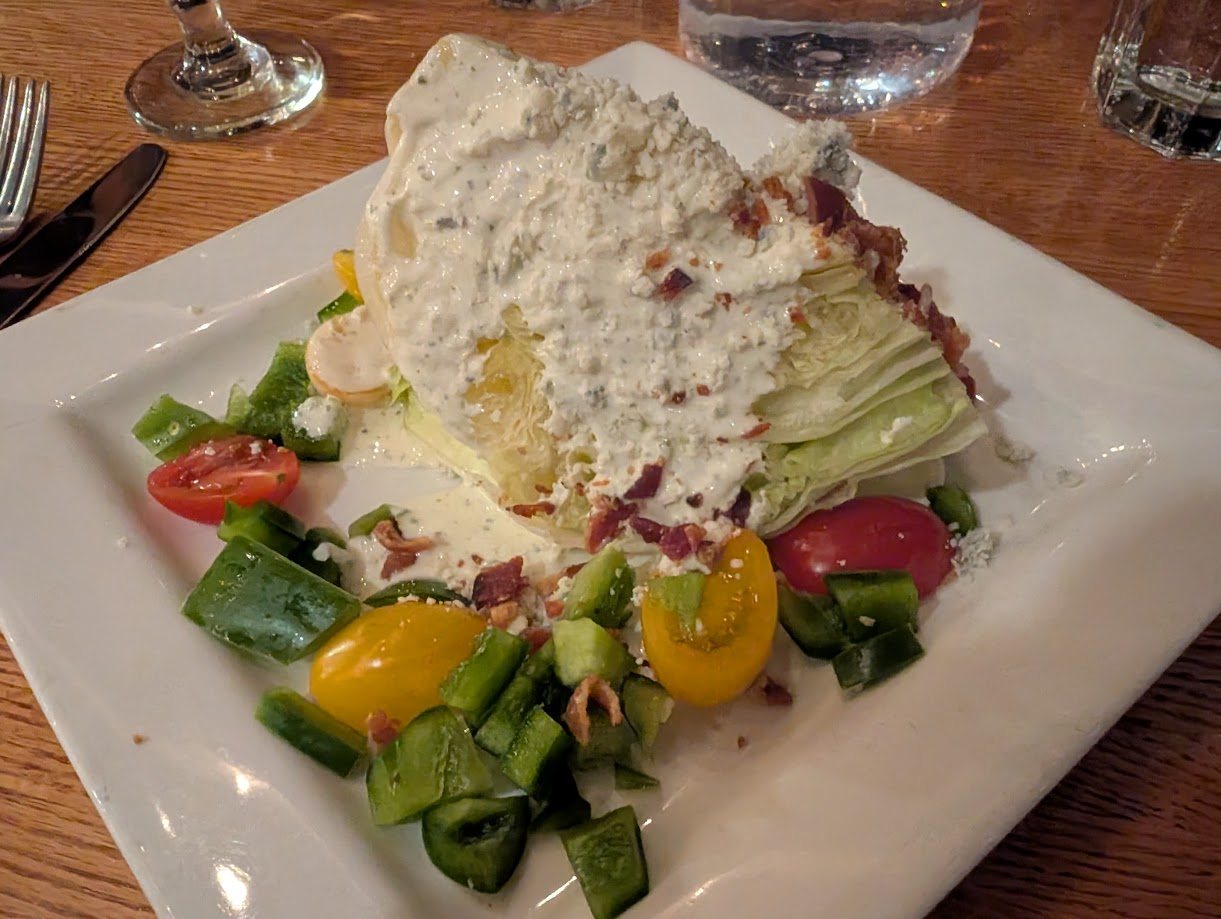 The wedge salad: blue cheese dressing, bacon, red and yellow tomatoes.